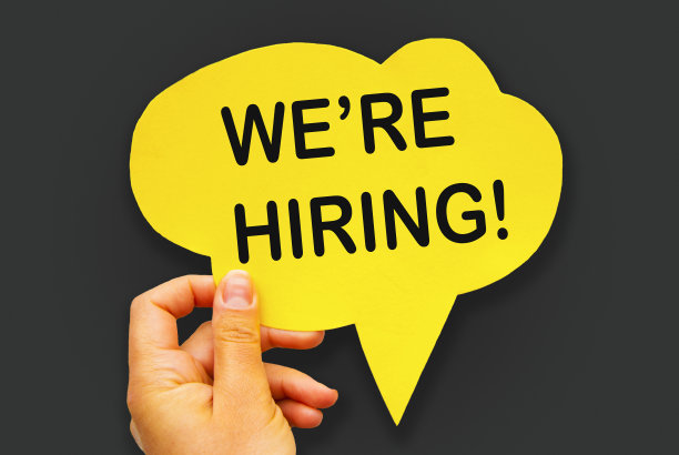手握黄色纸手剪语音气泡与WE’re HIRING概念，在灰色背景，孤立。图片下载