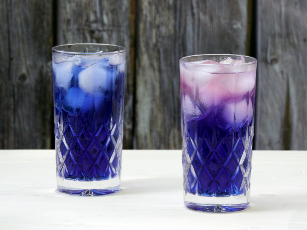 将柠檬汁倒入盛有蝴蝶豌豆花茶的玻璃杯中图片下载
