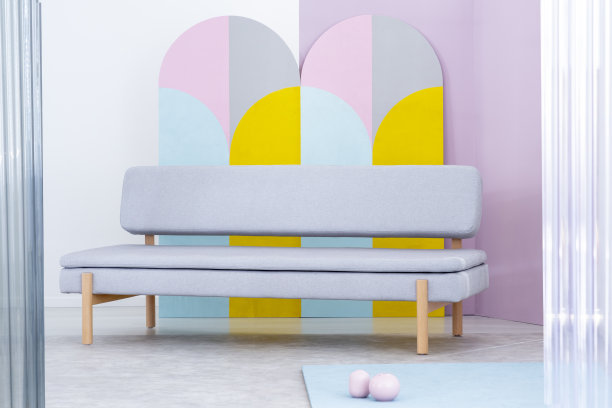 一个简单的真实照片，灰色沙发在多彩的客厅内部与几何墙装饰图片下载