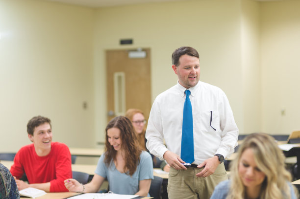 一位大学老师在教室里走来走去，和学生们交谈图片下载
