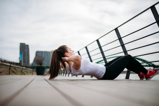 健美女孩做仰卧起坐的侧视图。图片下载