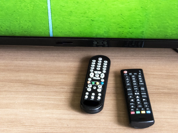 遥控器和电视，屏幕上有一个足球场图片下载