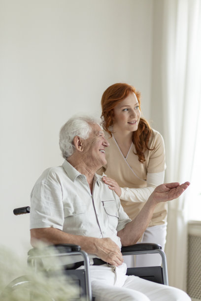 老人之家，轮椅上的病人微笑着与护士交谈图片下载