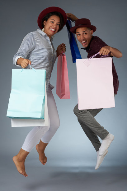 带着购物袋跳来跳去的年轻夫妇图片下载