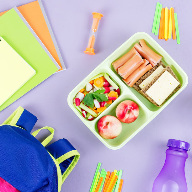 学校观念平铺。儿童背包，午餐盒，水瓶，笔记本，木桌上的马克笔图片下载