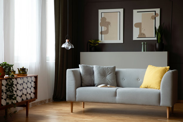 灰色休息室与黄色坐垫在真实照片的黑暗客厅内部与窗户与窗帘，复古的橱柜和灯图片下载