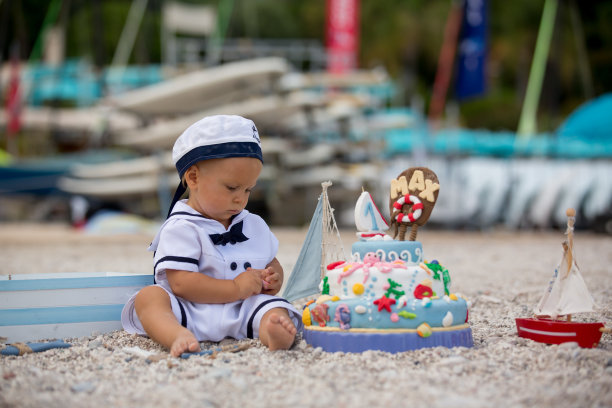 可爱的小男孩，用海洋主题蛋糕和装饰庆祝一岁生日图片下载
