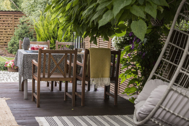 在一个阳光明媚的日子，木制花园椅子站在阳台上的真实照片图片下载