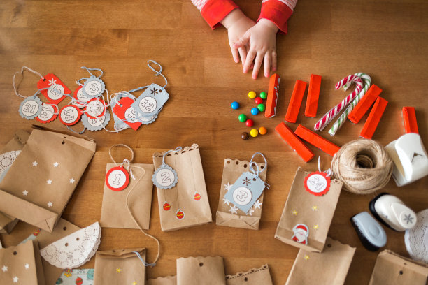 准备降临节日历。袋子和糖果在桌子上。用婴儿的小手去够糖果图片下载