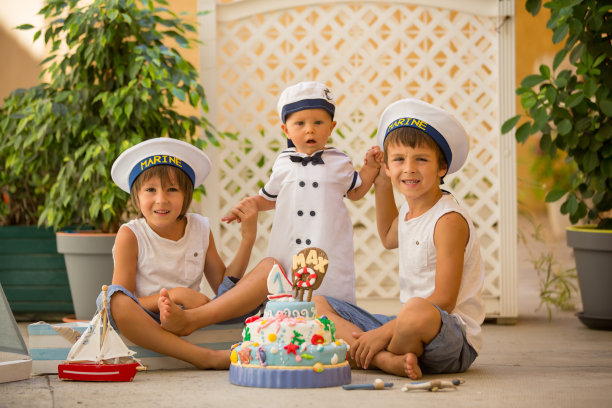 可爱的小男孩和他的兄弟们，用海洋主题的蛋糕和装饰庆祝他们的一岁生日图片下载