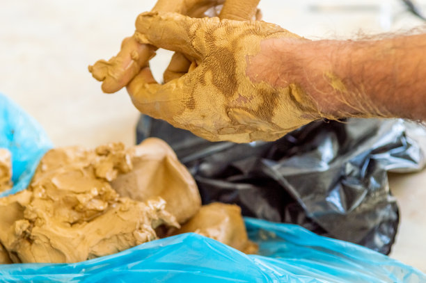 男艺术家在擦拭手上的泥土图片下载