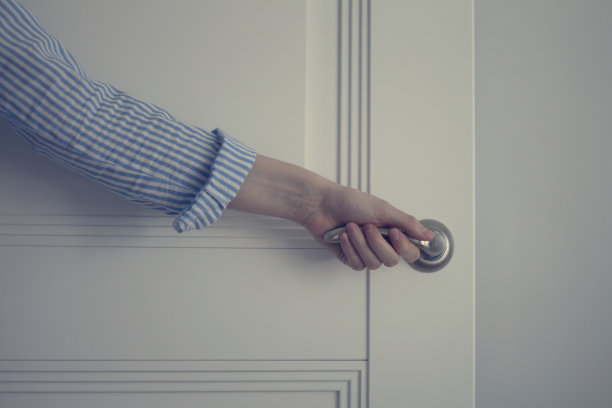 穿衬衫的女人打开了一扇白色的门图片下载