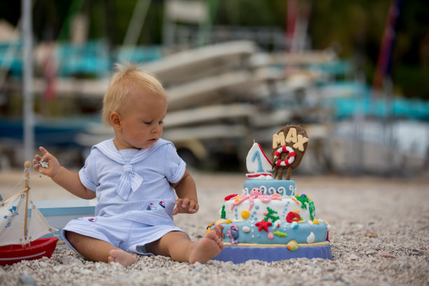 可爱的小男孩，用海洋主题蛋糕和装饰庆祝一岁生日图片下载