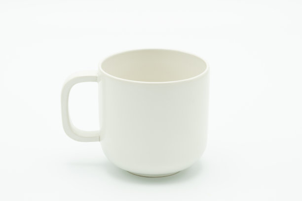 图片中间的白咖啡杯。有一个白色的背景作为媒体的原材料。与复制空间。图片下载