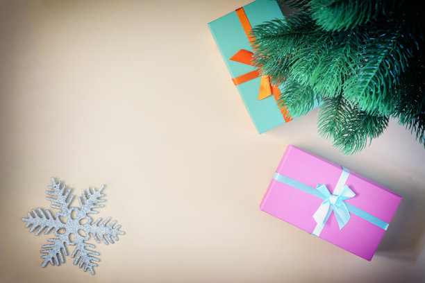 新年树下是装在彩色盒子里的礼物，上面是一幅图片。放置文本，复制空间。带有小图案的节日贺卡。图片下载