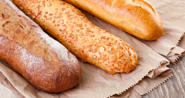 面包和烘焙产品隔离在白色。不同类型的面包:芝麻小面包，法式长棍面包，烤面包卷，乡村面包。图片下载