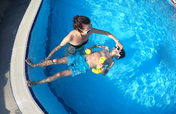 小男孩在室内游泳池上游泳课图片下载