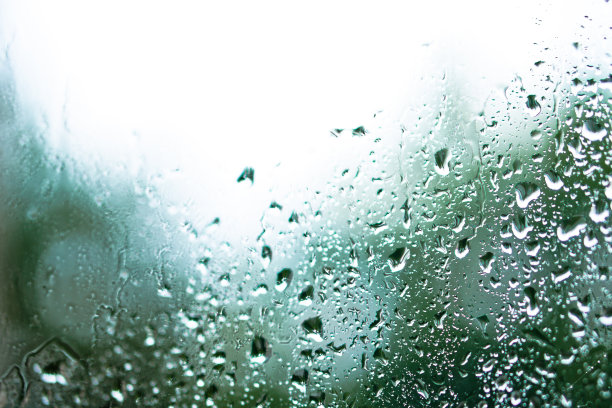 窗外多雨，秋天的天气。模糊的背景上的玻璃上的水滴。浪漫的肮脏的话题。设计素材照片图片下载