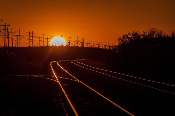 在一个金色的夏天日落时点亮的铁路轨道图片下载
