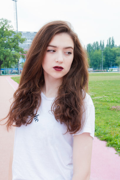 一个美丽严肃的女孩的近距离肖像松散的头发直发在白色的t恤图片下载