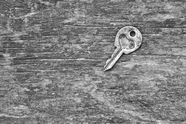 情人节或婚礼的浪漫背景。一把旧钥匙，在一块旧木板上刻着一颗心。设计素材照片图片下载