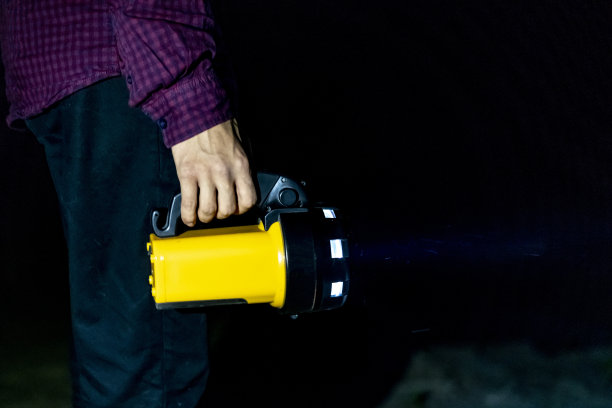 近距离手持手电筒手电筒在黑暗的自然森林户外站在沙滩上图片下载