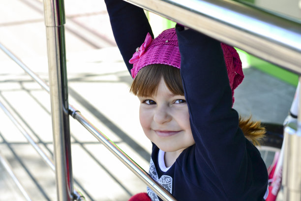 美丽的小女孩抓住楼梯底部的栏杆走了下去图片下载