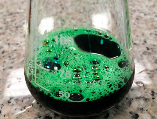 绿色化学品在锥形烧瓶。实验，冒泡化学反应。图片下载