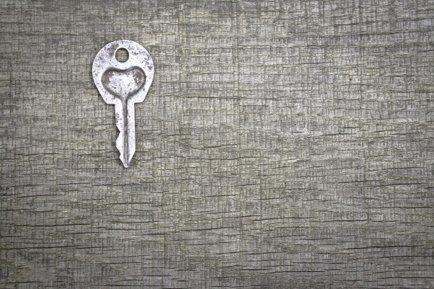 情人节或婚礼的浪漫背景。一把旧钥匙，在一块旧木板上刻着一颗心。设计素材照片图片下载