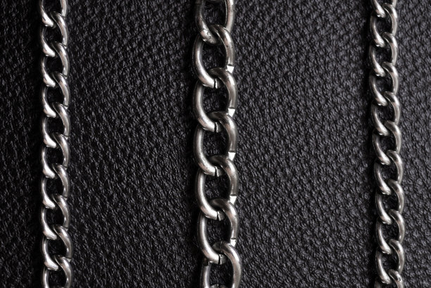 金属银链上奢华的黑色皮革纹理。图片下载