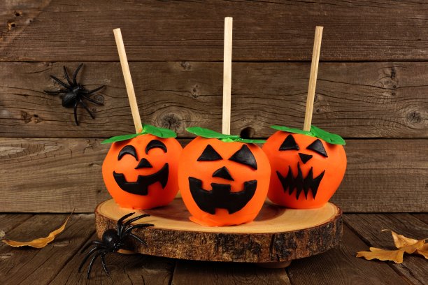 万圣节南瓜灯糖果苹果，场景以木头为背景图片下载