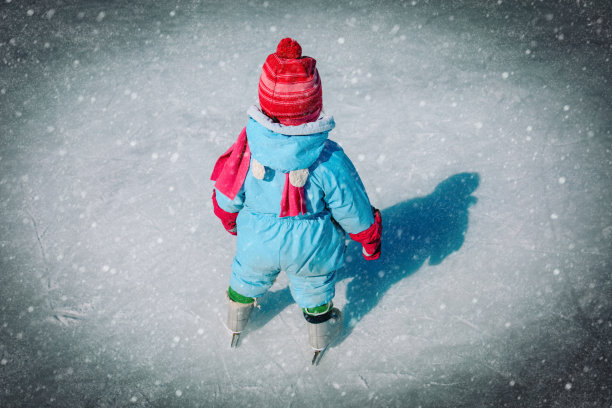 小女孩在学在冬天的雪上滑冰图片下载