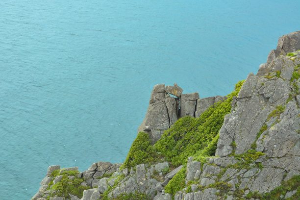 绿松石般的大海和绿色的岩石。对角线构图。极简主义景观图片下载