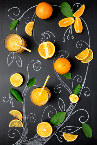 用鲜橙汁、部分橙子和在深色背景上画的树组成。创新食品的概念。图片下载