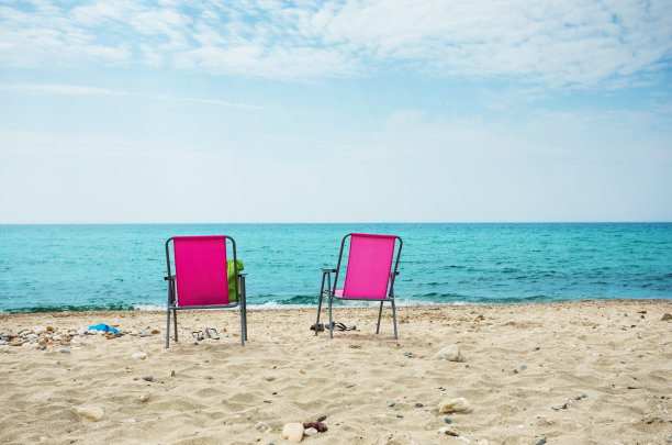 沙滩上的椅子，背景是大海和天空图片下载