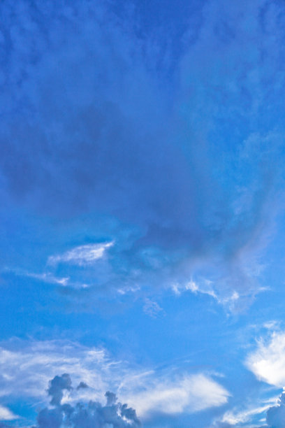 美丽的白色和灰色的云映衬着蓝色的天空。夏秋之日，从飞机上望向大气。设计素材照片图片下载