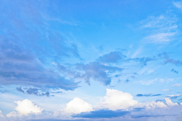 美丽的白色和灰色的云映衬着蓝色的天空。夏秋之日，从飞机上望向大气。设计素材照片图片下载