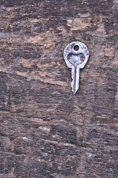 情人节或婚礼的浪漫背景。一把旧钥匙，在一块旧木板上刻着一颗心。设计素材照片图片下载