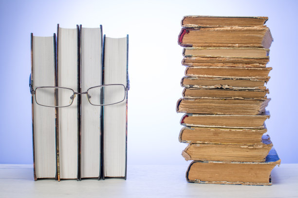 人脸由一些书籍制成，配上眼镜，堆满了破旧的旧书。阅读的概念。图片下载