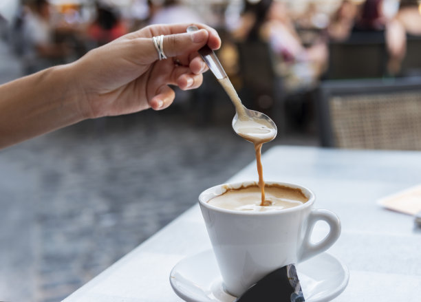 年轻女子在搅拌咖啡图片下载