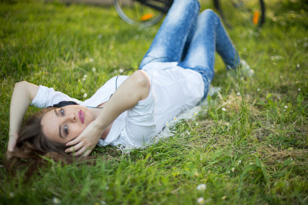 年轻女子躺在草地上图片下载