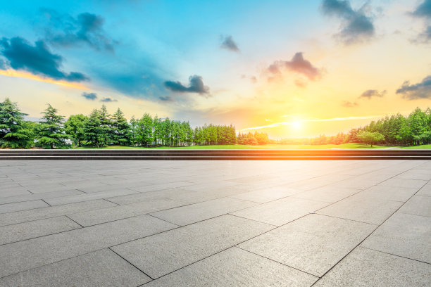 空旷的广场和日落时绿色的森林景色图片下载