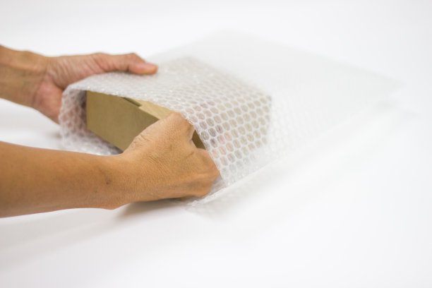 男人手持气泡膜，用于包装和保护易碎产品图片下载