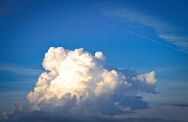 美丽的白色和灰色的云映衬着蓝色的天空。夏秋之日，从飞机上望向大气。设计素材照片图片下载