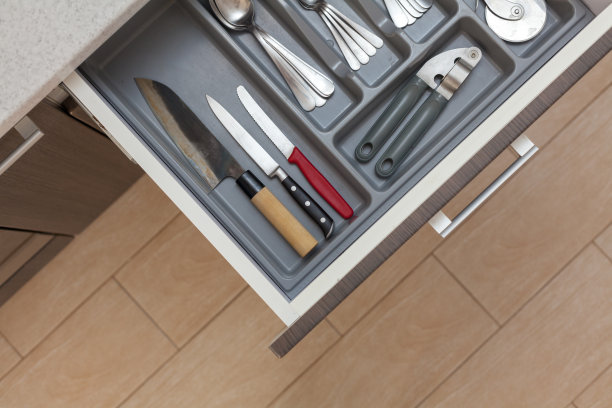 休闲、生活方式、居家生活理念。高角度俯视图裁剪照片打开新的现代木制厨房抽屉与不同的餐具，勺子，叉子，刀图片下载