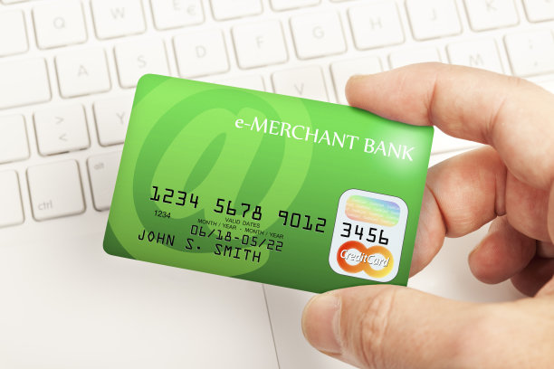 网上信用卡支付-手拿信用卡上方的键盘。梦幻设计和银行名称。图片下载