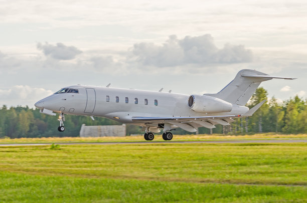傍晚日落时分，一架小飞机降落在跑道上。图片下载