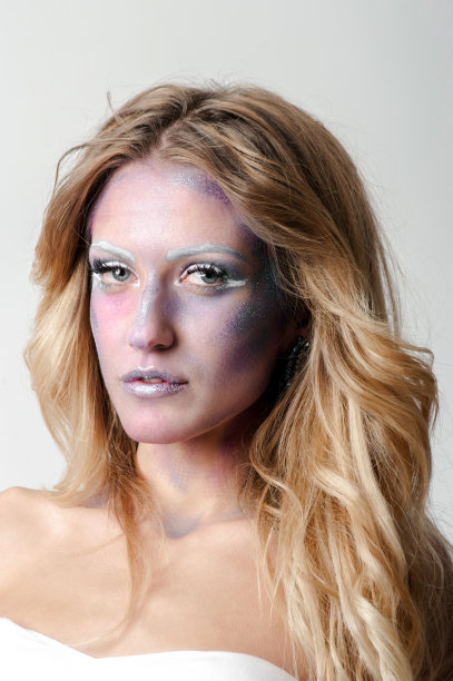 肖像迷人的女人与创造性的化妆摆姿势在黑色的背景图片下载