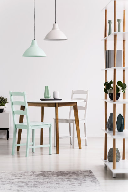 白色和绿色的餐厅内设有架子，木制桌椅上方的灯具。真实的照片图片下载