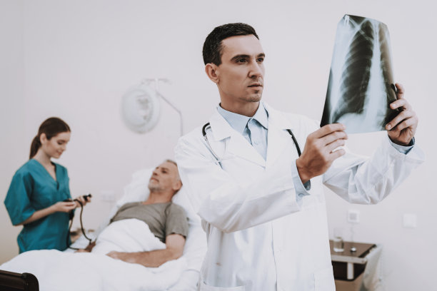 医生看照片在医院。诊所里的老人。图片下载